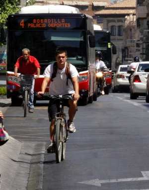 Un autobús circula detrás de dos ciclistas en la Gran Vía./ IDEAL - RAMÓN L. PÉREZ